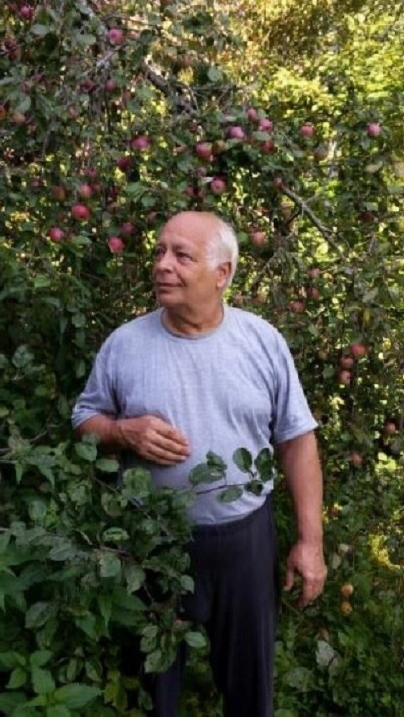 Муж Владимир смотрит на птичку, которая расчирикалась на дереве. 