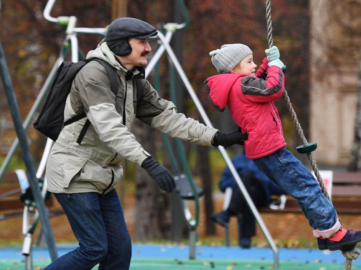    Мужчина с ребенком на детской площадке в День отца© РИА Новости / Кирилл Каллиников
