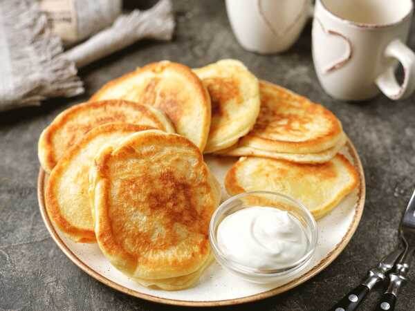 Мягкие, пышные и воздушные оладушки... что может быть вкуснее на завтрак или ужин? Если хотите, чтобы оладьи были максимально высокими, тогда муки нужно добавлять столько же, сколько и сметаны, а тесто должно получиться максимально густым.

Часто в такие оладьи добавляют тертое яблочко или кабачок, а также побольше сахара, так что при желании можете попробовать еще и такой вариант.