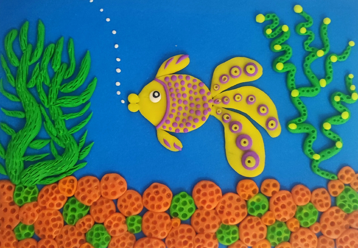 Готовый вариант аппликации из пластилина на цветном картоне Золотая рыбка.