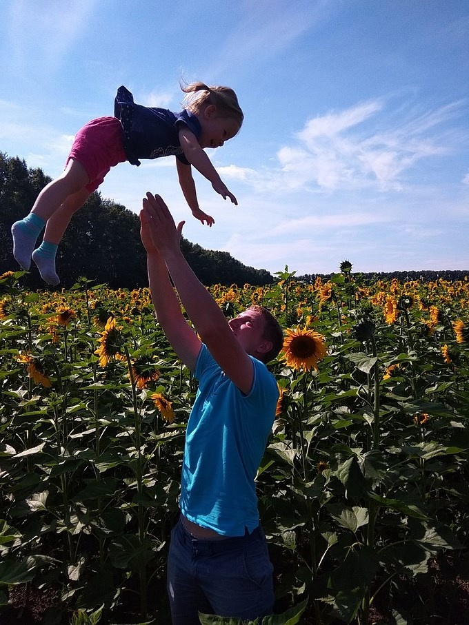 Отец подкидывает дочку в воздух