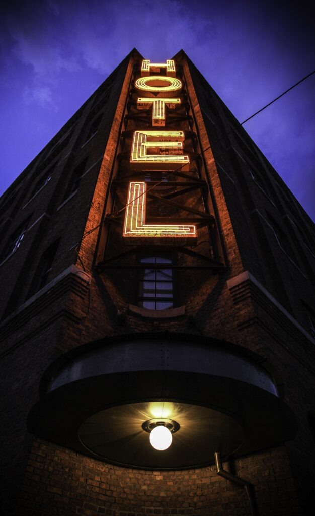    A vertical shot of a big building with a hotel sign and a dark blue sky in the background Вячеслав Марченко