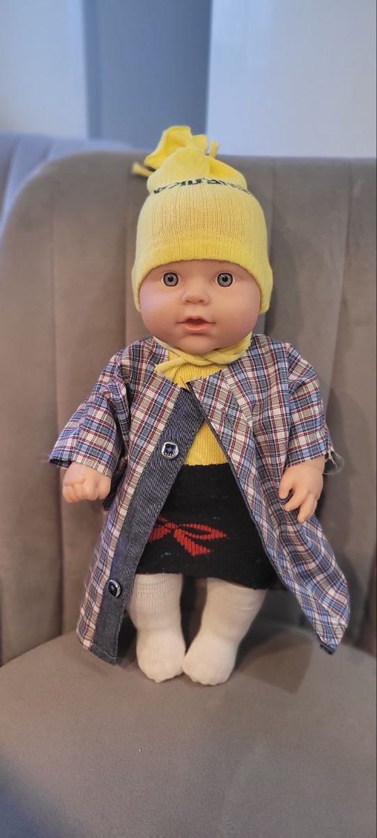 Это Лиза. Для неё сшили комбинезон, который, надеюсь, нельзя снять, юбку из верхней части носка, нечто вроде пальто, шапку и гольфы.