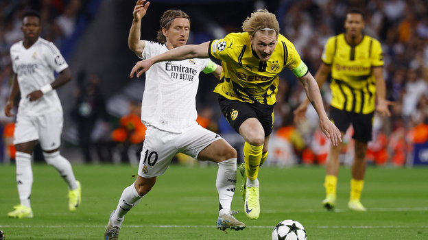    Лука Модрич (№10) в борьбе с Юлианом Брандтом в матче «Реал» — «Боруссия». Reuters