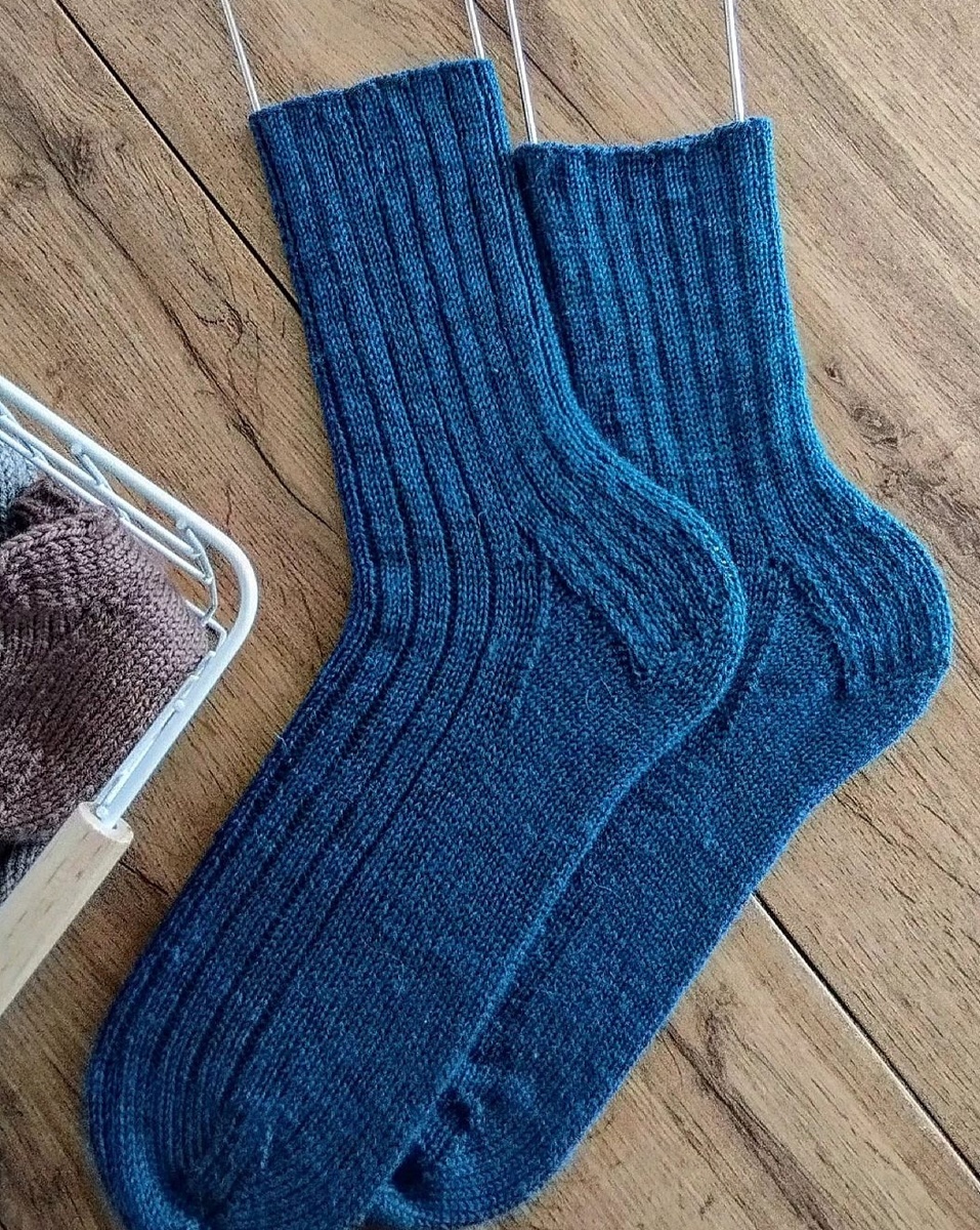 Носки вяжутся на чулочных спицах сверху вниз от манжеты. Пятка "подкова" с укреплённой стенкой. 

 Размер : 43-44

 Спицы: 2,5 см 

 Пряжа: Alize Superwash

  Описание: 

 На спицы 2,5 набрать 64 петли, распределить равномерно на 4 спицы (по 16 петель на каждую). Резинка отсутствует, начинаем вязать с поголёнка. . Вяжем узором: *1 изн*3 лиц*1изн.  Этим узором вяжем 17 см .  После поголëнка пристураем к пятке. 

 На пятку берем половину петель от общего количества ( 32 петли) . Пятка вяжется на 1 ой и 4 ой спицах ( можно перенести на одну для удобства). 

 Укреплённая пятка: 

 1й ряд.: кром. петлю снимаем, нить за работой, 1 лицевая петля, 2 ю снимаем не провязанной, нить за работой, вяжем до конца ряда. 

 2 й ряд: кром. петлю снимаем, все петли изнаночные, последняя петля кромочная ( изнаночной). 

 Повторяем 1 й и 2 й ряды до нужной высоты пятки. (32 ряда). 

 Далее вяжем поворот пятки. 

 Делим петли на 3 части : 11/10/11 петель( боковая часть / центральная часть / боковая часть). 

 1 ряд : провязываем 11 петель первой боковой части, провязываем 7 петель центральной части, 2 лицевые петли вместе с наклоном влево, 1 лицевая петля, развернуть вязание. 

 2 ряд: 1 ю петлю снимаем, нить перед работой, провязываем 5 изнаночных петель изнаночными, 2 изнаночнве вместе, 1 изнаночная. Развернуть вязание. 

 По бокам у нас образуются промежутки между центральной и боковыми частями. 

 3 ряд : 1 ю петлю снять, вяжем петли до нашего промежутка, первую петлю до промежутка, и первую петлю после промежутка провязывыем вместе лицевой петлёй с наклоном вправо, 1 лицевая петля, разворачиваем вязание. 

 4 ряд: 1 ю петлю снять, далее вяжем изнаночные петли до нашего промежутка, петлю до промежутка и после провязывем вместе одной изнаночной петлёй, изнаночная петля. Разворачиваем вязание. 

 Повторяем 3 й и 4 й ряды пока не закончатся петли на боковых частях. После этого на спице остаётся 20 петель. 

 Далее будем поднимать из кромочных петель боковых частей пятки петли для, клина подъёма. Всего нужно поднять 16+1 петлю из промежутка. Петли пятки и клина подъёма на 1 й и 4 й спицах нужно разделить поровну ( по 27 петель) . Теперь у нас вязание на 4 спицах. 1 я спица -27 петель, 1 я спица - 16 петель, 3 спица -16 петель, 4 я спица - 27 петель. Всего - 86 петель. 

 Клин подъёма стопы : 

 1 ряд. 

 1 я спица - вяжем все петли лицевые до последних 3 петель, 2 петли вместе лицевой с наклоном вправо, 1 лицевая петля. 

 2 я и 3 я спицы провязываем все петли лицевыми. 

 4 я спица- 1 лицевая петля, 2 вместе лицевой с наклоном влево, лицевые петли до конца спицы.

 2 ряд : вяжем все петли лицевые ( без убавок). Убавки делаем только на 1 й и 4 й спицах. Убавляем пока на спицах не останется по 16 петель. Всего на 4 х спицах должно остаться 64 петли. 

 Далее вяжем стопу на необходимую длинну (можно посмотреть по таблице размеров . После стопы приступаем к вязанию мыска.

 Мысок: 

 Вязание мыска начинается с середины мизинца. На 4 х спицах должно быть одинаковое количество петель. Убавки делаются в каждом втором ряду. ( 1 ряд с убавками, 2 ряд лицевые). 

 1 ряд. 

 1 спица: все петли лицевые до последних 3 х петель, 2 лицевые вместе с наклоном вправо, 1 лицевая петля. 

 2 спица : 1 лицевая петля, 2 лицевые вместе с наклоном влево, лицевые петли до конца спицы. 

 3 спица: лицевые петли до последних 3 петель, 2 лицевые вместе с наклоном вправо, 1 лицевая петля. 

 4 спица: 1 лицевая петля, 2 лицевые вместе с наклоном влево, лицевые петли до конца спицы. 

 2 ряд. Все петли лицевые без убавок. 

 Делаем убавки пока на спицах не останется, 16 петель, по 4 петли на каждой спице. Далее распределяем петли на 2 спицы поровну и выполняем трикотажный шов. 

 Как выполнять трикотажный шов есть подробное видео на моем канале. 

