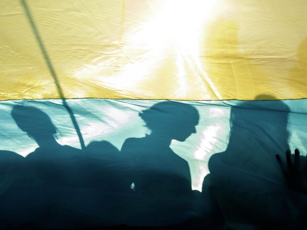    Люди с флагом Украины© AP Photo / Evgeniy Maloletka