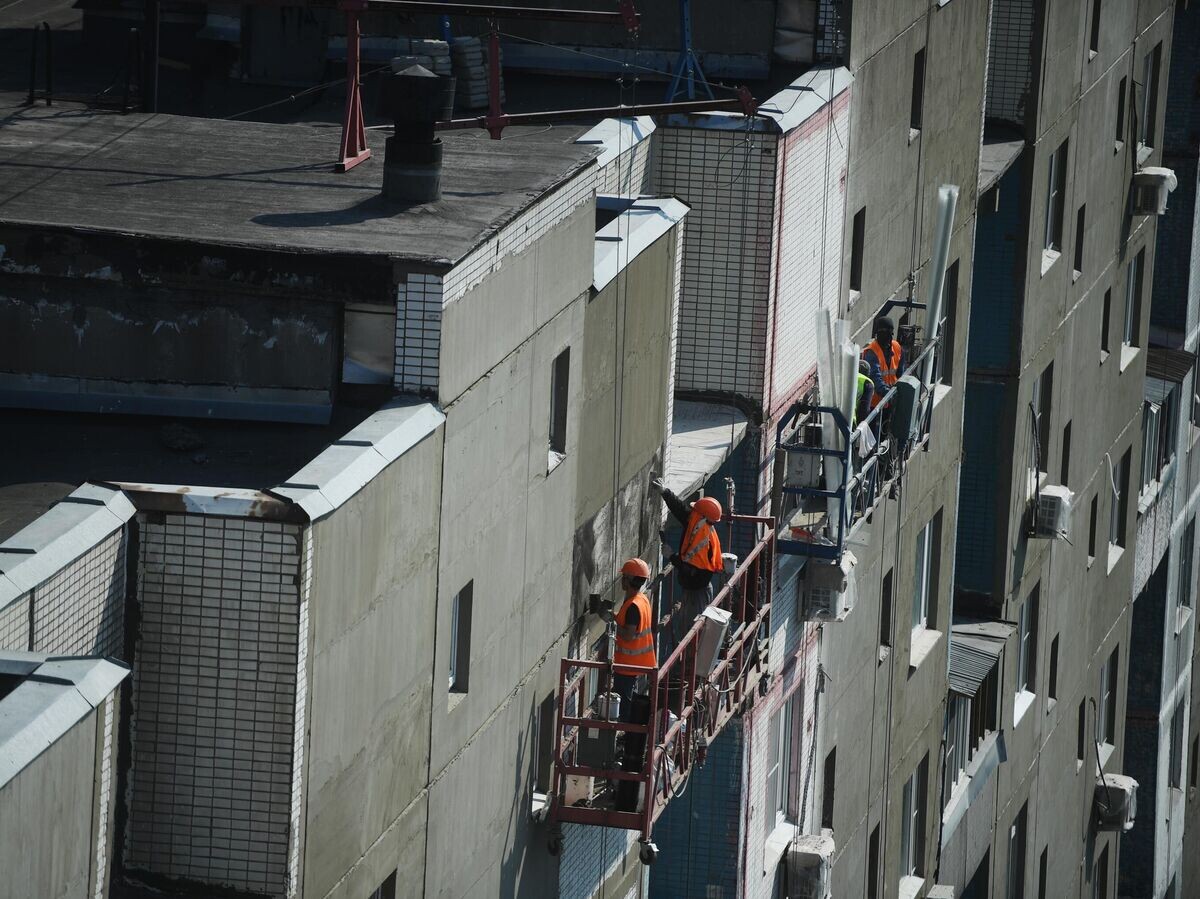    Рабочие проводят ремонт жилого дома© РИА Новости / Евгений Одиноков