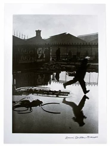 Правильное название фотографии Анри Картье-Брессона, на которой человек прыгает через лужу, — «За вокзалом „Сен-Лазар“» (Derrière la Gare Saint-Lazare)