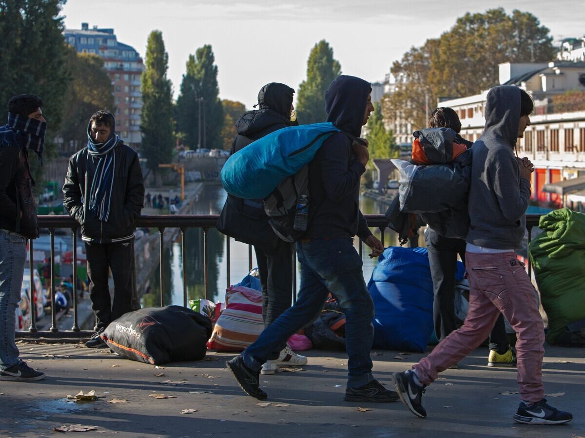    Мужчины в районе Сталинград в Париже, где находится лагерь беженцев© РИА Новости / Ирина Калашникова