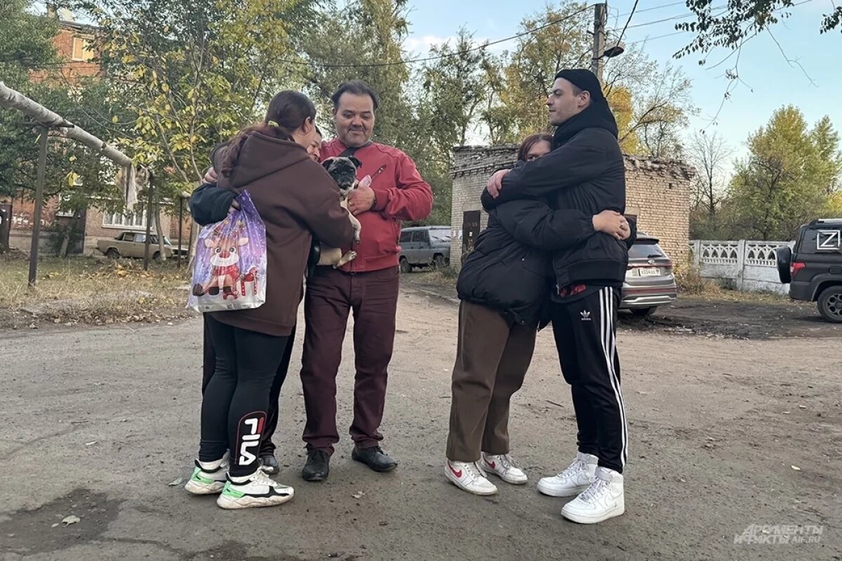    На фото возле одного из пунктов временного размещения семья беженцев. Мужчина в красном — отец семейства Владимир, молодой человек в черном — сын Иван, молодые девушки — дочери Владимира.