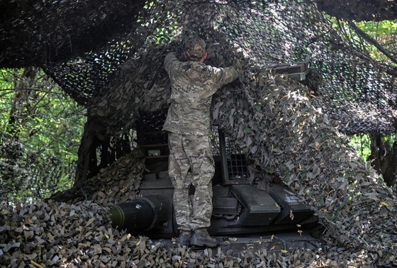    Танкист ВС РФ маскирует танк в зоне проведения СВО