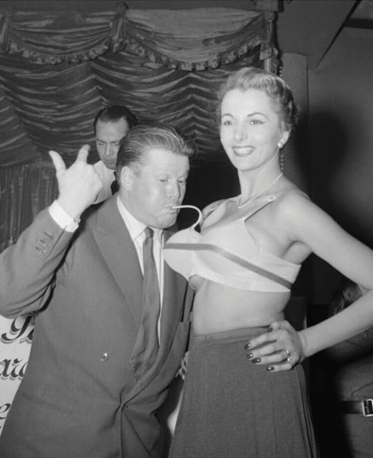 Звезда Франции Жак Ангельвен (Jacques Angelvin) надувает бюстгальтер. 1952.