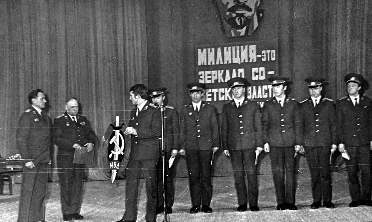 Авторитетный ветеран ОВД А.Г.Цаплин вручает эмблему МВД в надёжные руки молодого поколения дубненской милиции. Фото 1982 года из личного архива автора.