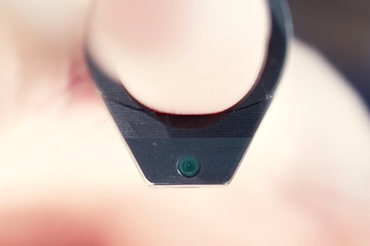 С помощью камеры можно увидеть конец пальца и поверхность под ним.