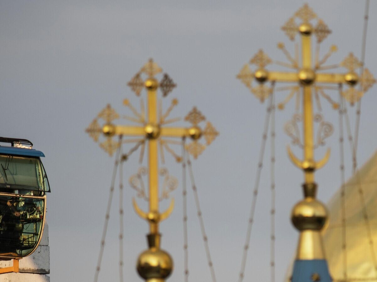    Кабина строительного крана и кресты на куполах храма© РИА Новости / Владимир Астапкович