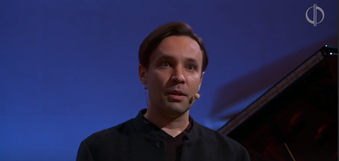 Ярослав Тимофеев, музыковед, лектор, композитор, звонарь, клавишник группы OQJAV, ведущий концертов Московской филармонии. Взято из Википедии. Скриншот  из концертной записи Московской филармонии  в VK.