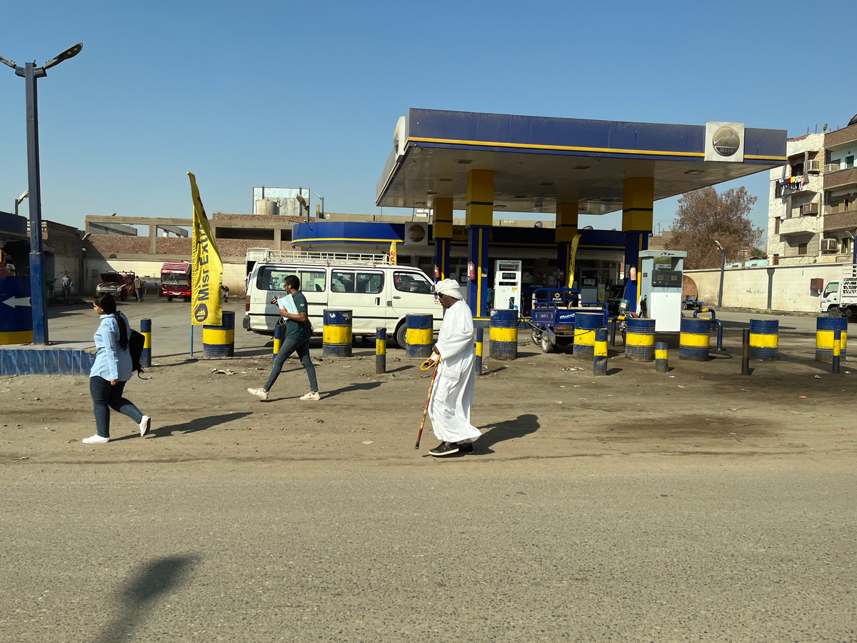 Египтяне разных поколений , в национальной и европейской одежде, спешащие по делам. Асуан. 