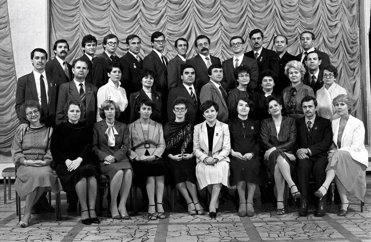 Сидят слева направо: 1. Петрова Надежда Николаевна - референт общества «Знание». 2. Козленко Ольга Ивановна – ответственный секретарь камазовской организации общества «Знание». 3. ... Светлана ... - народный контроль. 4. Зиятдинова Люция Хабровна – методист парткабинета парткома КАМАЗа. 5. Пугачева Татьяна Леонидовна – библиотекарь парткома КАМАЗа. 6. Вильданова Халида Хасановна - общий отдел. 7. Галиуллина Гулия Гаязовна Валиуллина. 8. Дворядкина Тамара ... - машинистка парткома КАМАЗа. 9. Сафин Нурсил Кутдусович - партком КАМАЗа.10. Скворцова Нина Николаевна - главный редактор редакции радиовещания «Шаги КАМАЗа». Во втором ряду слева направо: 1. Бубличенко Александр Леонидович – инструктор идеологического отдела парткома КАМАЗа. 2. Архипов Анатолий Петрович – член партийной комиссии – председатель парткомиссии парткома КАМАЗа. 3. Гоголенко Татьяна Алексеевна – статист, сектор учёта. 4. ... Дания ...– партком КАМАЗа. 5. Нуретдинов Гумер Хасанзанович – председатель профкома КАМАЗа. 6. Ларин Николай Григорьевич – секретарь комитета комсомола КАМАЗа. 7. Макаримова Ляля Хамитовна – партком КАМАЗа. 8. Хафизова Роза Василовна - сектор учета парткома КАМАЗа. 9. Криворученко Надежда Кузьминична - заведующая сектором учёта парткома КАМАЗ. 10. Мухамадеев Рафаэль Мирзанурович – заместитель секретаря парткома КАМАЗа по организационной работе. 11. Байбекова Ольга Борисовна – сектор учёта парткома КАМАЗа.
В третьем ряду слева направо: 1. Полянцев Владимир Николаевич - партком КАМАЗа. 2. Шафигуллин Шарифулла Гарифуллович - комитет комсомола КАМАЗа. 3. Назмутдинов Ахат Хайретдинович – комитет народного контроля. 4. Дутов Анатолий Александрович – председатель комитета ДОСААФ КАМАЗа. 5. Агеев Анатолий Евгеньевич - комитет комсомола завода двигателей. 6. Салихов Рашит Масгутович – секретарь парткома агрегатного завода.7. Медведев Михаил Михайлович. 8. Белоненко Олег Дмитриевич – заместитель секретаря парткома КАМАЗа по идеологии. 9. Королев Виктор Михайлович –заместитель секретаря парткома КАМАЗа. 10. Аракчеев Валерий Леонидович - главный редактор газеты «Рабочий КАМАЗА». 11. Костюнин Александр Николаевич – председатель комитета народного контроля.