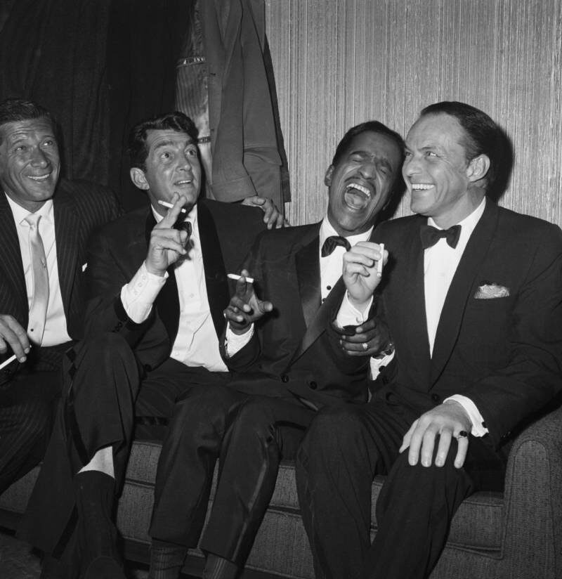 Джен Мюррей (слева) сидит рядом с участниками Rat Pack Дином Мартином, Сэмми Дэвисом-младшим и Фрэнком Синатрой во время отдыха группы за кулисами Карнеги-холла. 1961 год. 
|| Беттманн/Getty Images