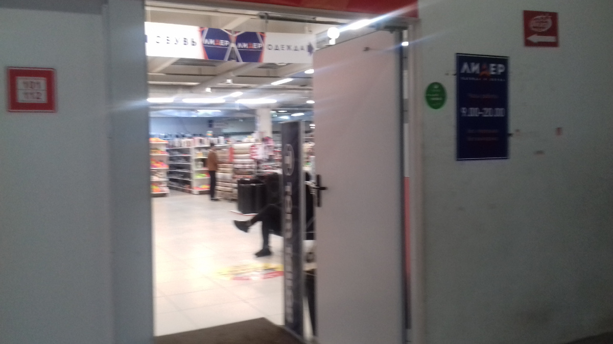 Рамки в магазине с одеждой. Сидит охранник и еще установлены рамки.