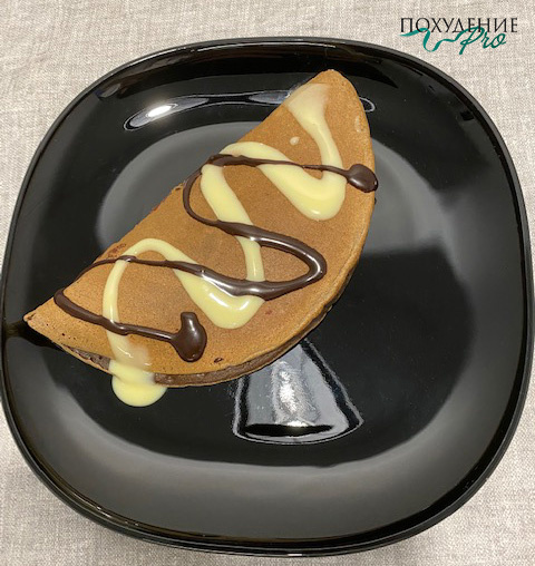 Блин полит низкокалорийным шоколадным сиропом и сгущенным молоком 