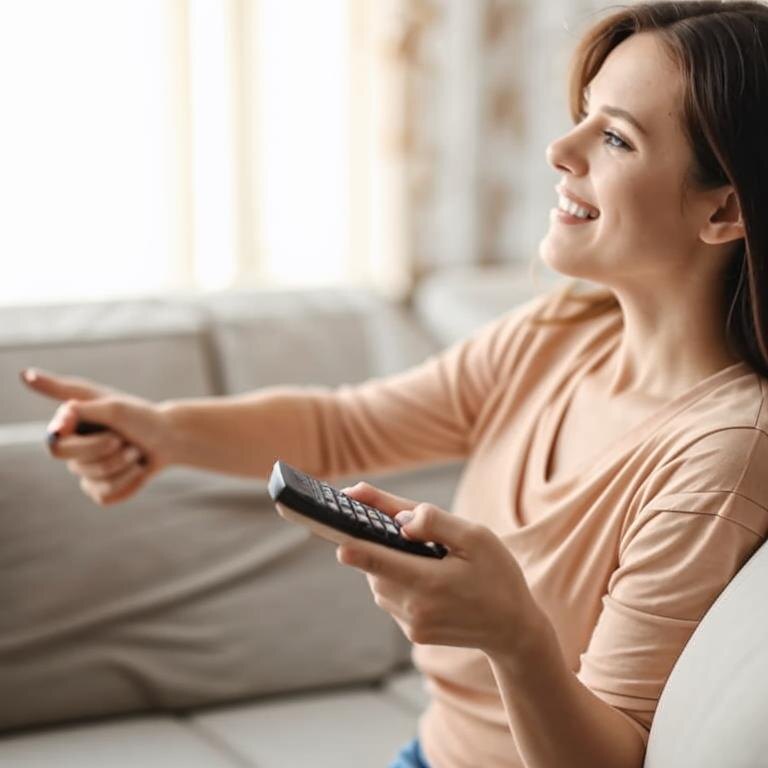 Девушка смотрит тв.