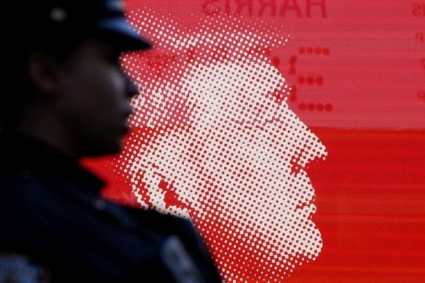    Сотрудник полиции Нью-Йорка стоит перед изображением кандидата в президенты от Республиканской партии и бывшего президента США Дональда Трампа возле Медисон-сквер-гарден в Нью-Йорке, США, 27 октября 2024 года. Фото: David Dee Delgado / Reuters