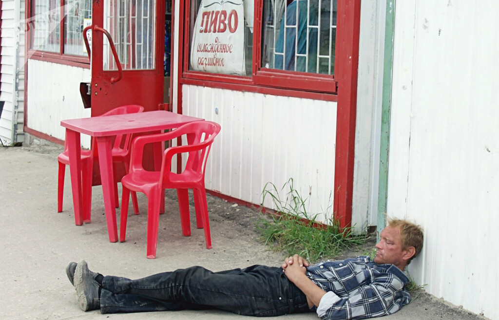 Любитель пива прилег отдохнуть около пивного заведения
