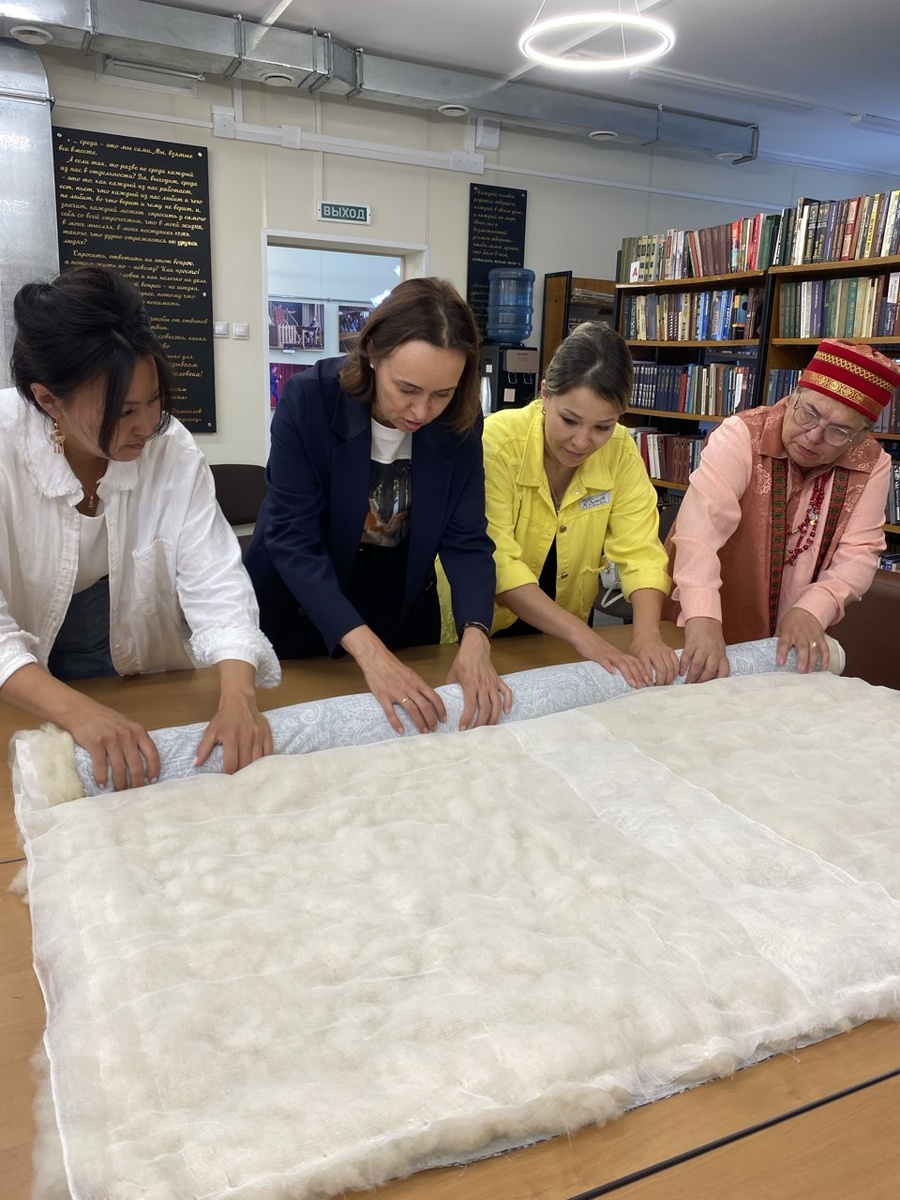 Министр культуры Иркутской области Олеся Николаевна Полунина участвует в процессе сворачивания одеяла (июль 2024) 