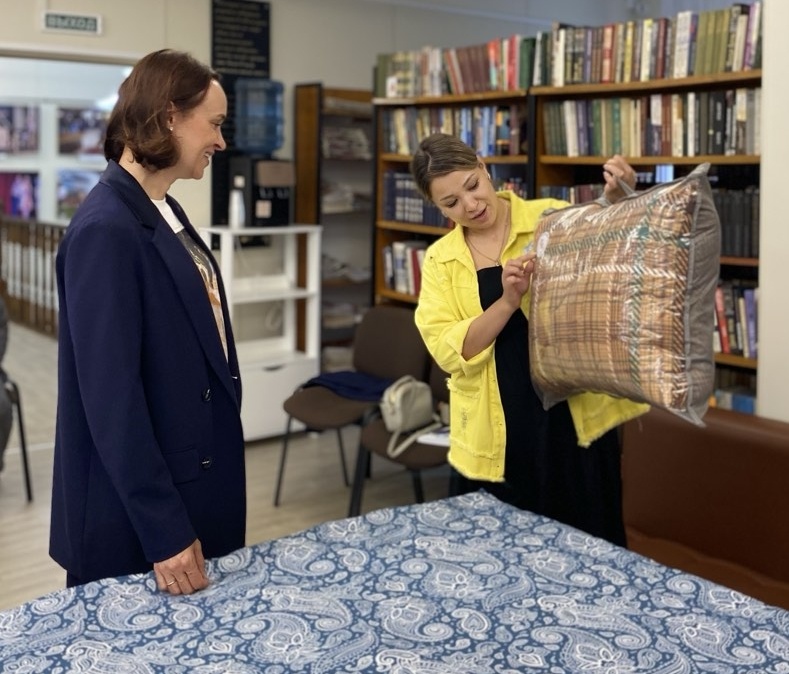 Председатель Комитета по культуре Аларского района Мария Владимировна Радова презентует одеяло ручной работы министру. 