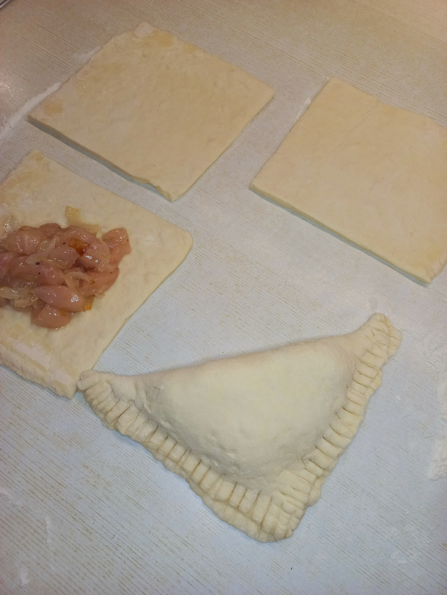 Выкладываем начинку, придаем пирожкам треугольную форму.