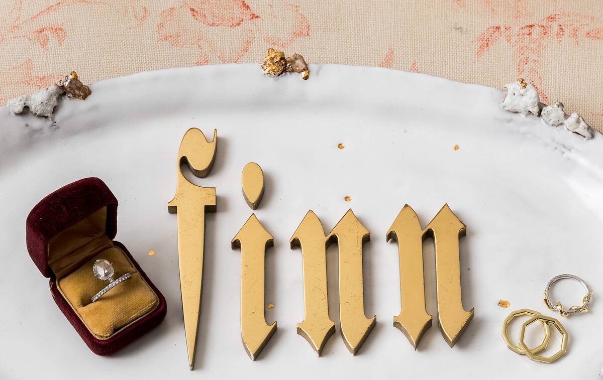 Обручальное кольцо из платины и бриллианта огранки «роза» в винтажной шкатулке для драгоценностей, пара колец-багет и шарнирное кольцо в форме змеи выставлены на подносе Halo от Minh Singer из Гринпойнт-Хилл.