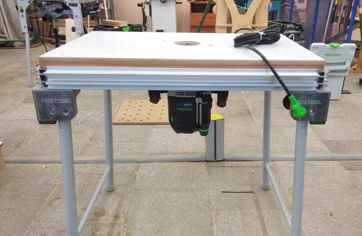 Просто фрезер, закрепленный снизу столешницы. Вполне рабочий вариант