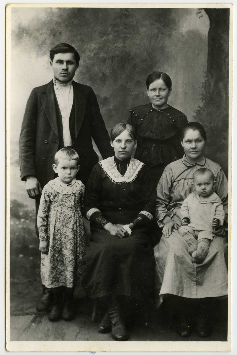 Елфимова Афанасия Кузьминична сидит с сыном Виктором. Сзади стоят сестра Залесова Евгения Кузьминична с дочерью Агнией (стоит слева) и брат Кропанцев Максим Кузьмич с женой Марией Исаевной (сидит в центре). д. Алапаиха, 1925 г.