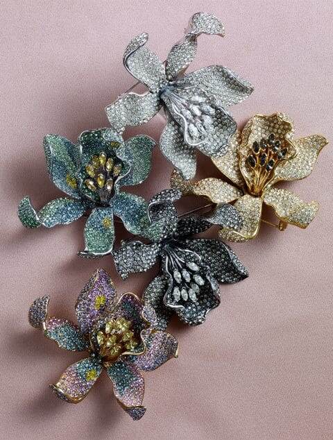 Ювелир Ciner изготавливает каждое изделие на заказ — и вручную — в своей мастерской в ​​Нью-Йорке, что позволяет им экспериментировать с цветом, как эти цветущие броши-орхидеи, доступные в оттенках зеленого и розового , а также в  серебряном , золотом и черном цветах.