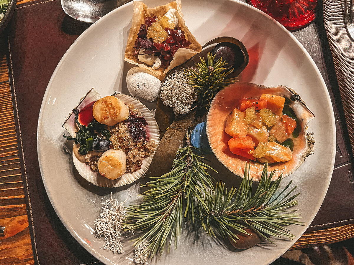 Сугудай из лосося с щучьей икрой, солёными томатами и томатной водой, мурманские гребешки на "песке" Баренцева моря с устричной травой и тартар из двух видов мяса оленя в мурманском ресторане «Царская охота» 