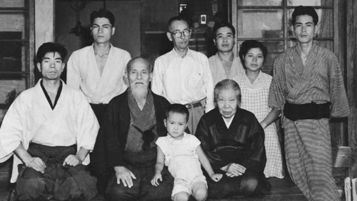 Морихей Уэсиба с супругой (в центре), между ними внук - Моритеру Уэсиба (3-й Дошу), за ними стоит сын - Киссёмару Уэсиба (2-й Дошу). Слева - Морихиро Сайто.