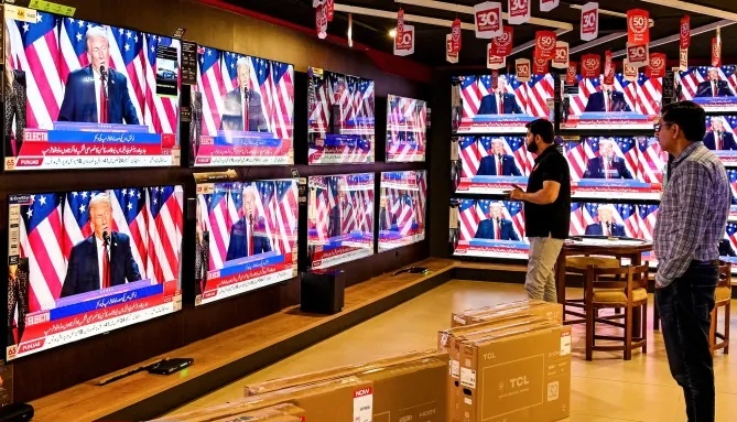 6 ноября 2024 года в магазине в Исламабаде, Пакистан, мужчины смотрят телевизионную трансляцию, на которой Дональд Трамп выступает на мероприятии в честь выборов в американском штате Флорида. Фарук Наим / AFP / Getty Images.