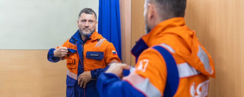    Сотрудник нефтяной компании примеряет спецодежду