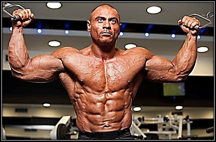 На фото бодибилдер тренируется и показывает форму.