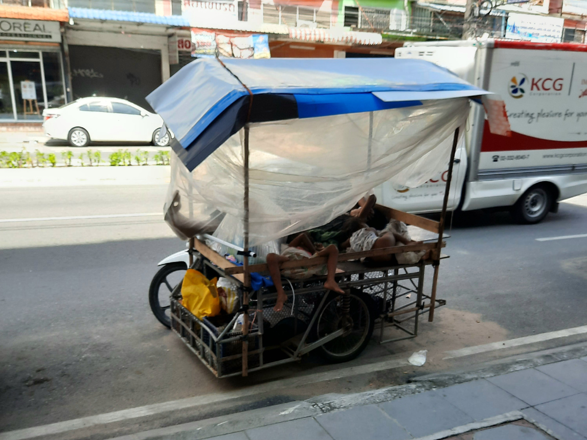 Целая семья отдыхает от Солнца в самодельной повозке. 
