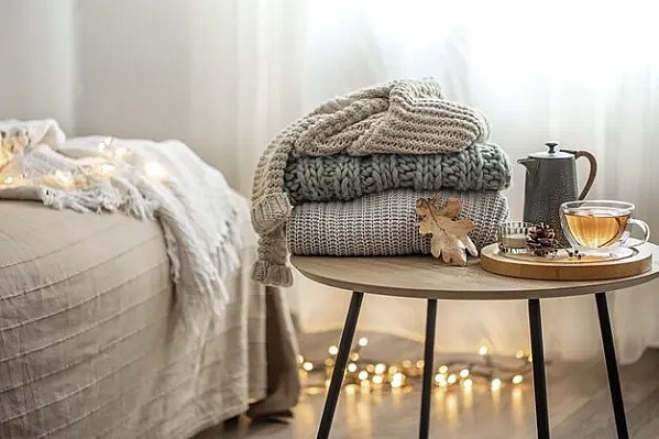 Источник: https://img.freepik.com/premium-photo/home-autumn-composition-with-tea-knitted-sweaters-interior-room-blurred-background_169016-13693.jpg?w=996