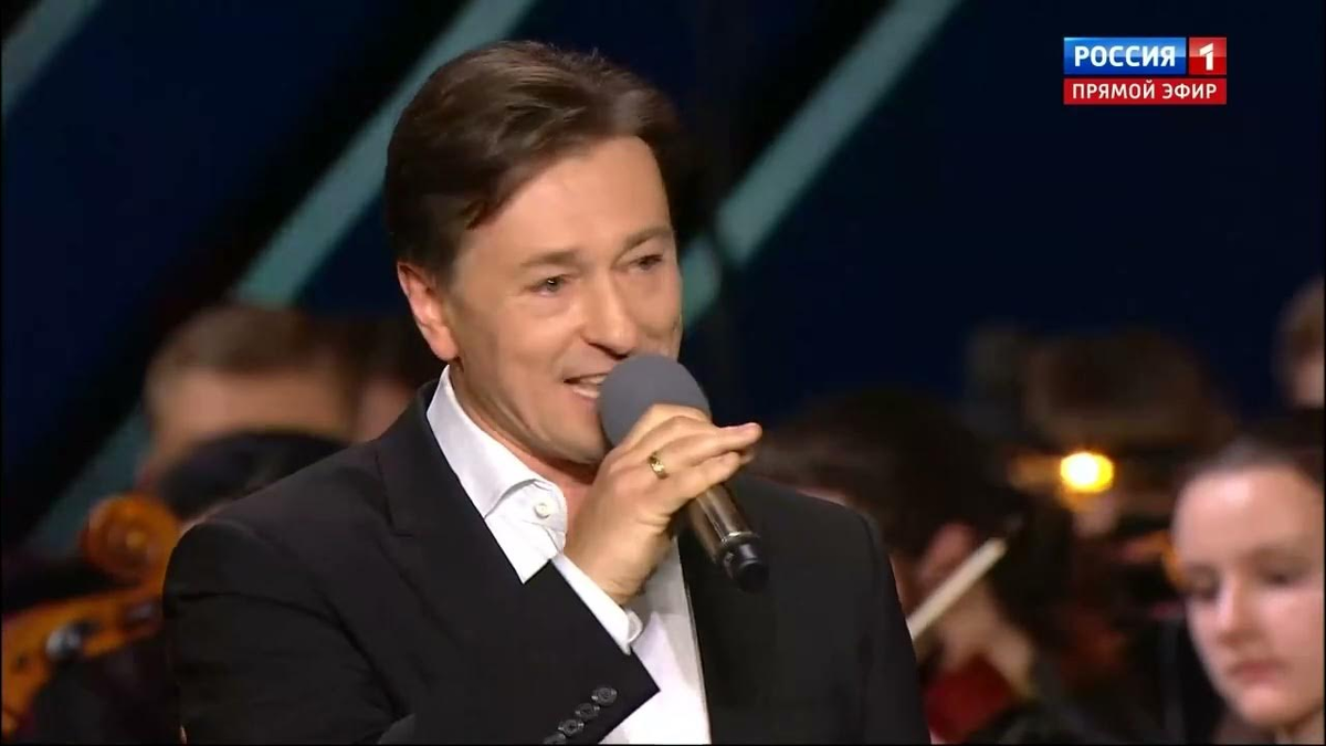 Сергей Безруков "исполняет" песню «Да разве сердце позабудет», открывая юбилейный концерт Александры Пахмутовой.