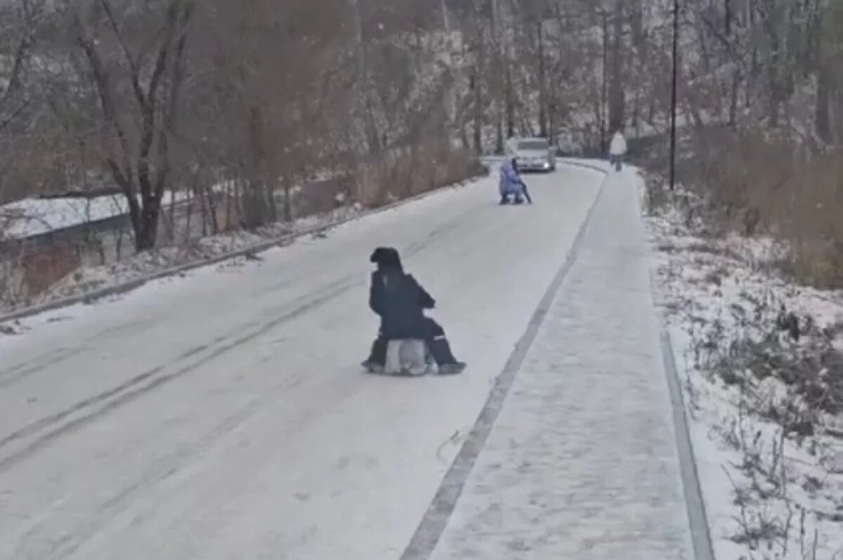    Дети на ватрушках катаются по проезжей части в Новосибирске