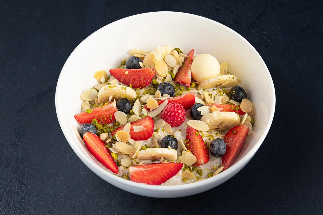 Овсяная каша на воде с ягодами, сливочным маслом и орехами