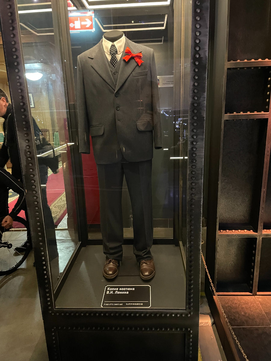 … и манекен. Пролетарский картуз и мелкобуржуазный котелок, в которых правдивые свидетели одновременно видели Ленина, условно не показан.