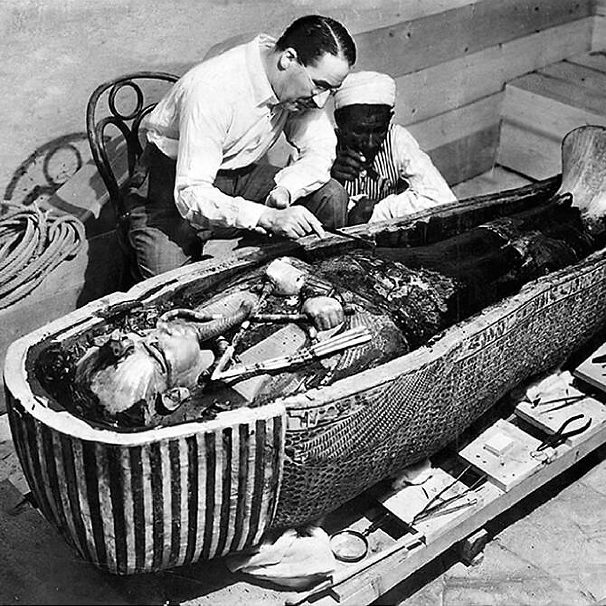 Археолог Говард Картер работает над гробницей фараона Тутанхамона вскоре после ее открытия. Wikimedia.