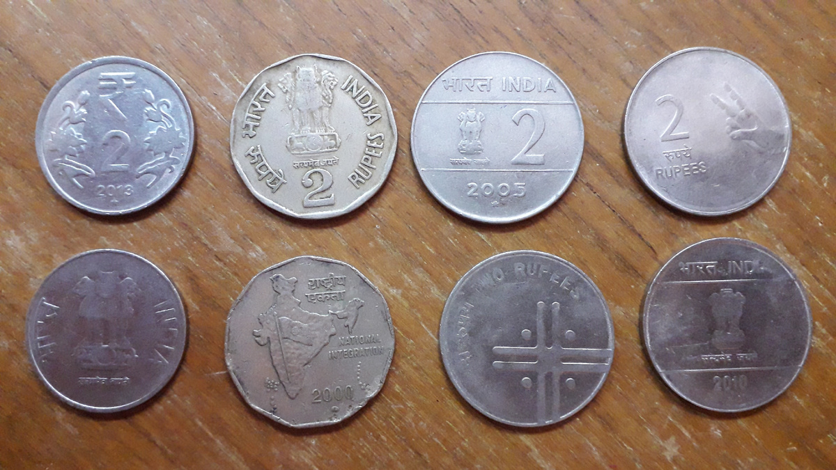 Индийские рупии номиналом в две рупии. Верхний ряд -- сторона номинала, нижний ряд -- реверс. 