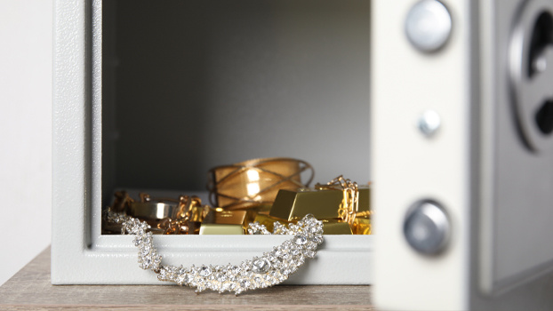 Ювелирные украшения из золота лежат в открытом сейфе