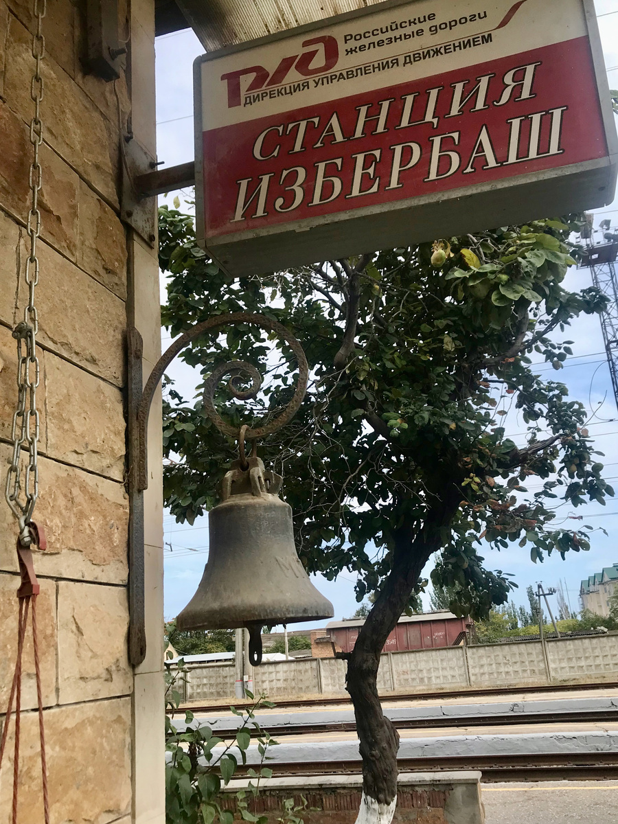 Надо сказать, что подавляющее большинство станций на этом участке Северо-Кавказской ж/д выполнено в едином стиле. Здание вокзала, пакгауз, водонапорная башня-всё из жёлтого песчаника в промышленной архитектуре начала ХХ века. Этот колокол, видимо, висит здесь ещё с тех пор, как царь-батюшка Николай II в 1914- м году проехал по вновь проложенной ветке до Дербента и далее до театра военных действий.